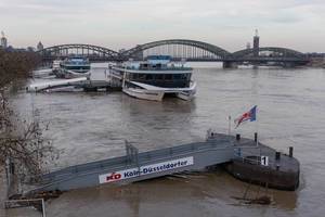Bootssteg und Schiffe bei Hochwasser mit der Hohenzollernbrücke im Hintergrund