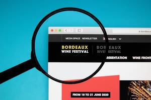 Bordeaux Wine Festival website on a computer screen with a magnifying glass