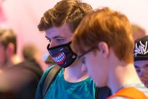 Boy with printed mouth mask at German games fair Gamescom 2019