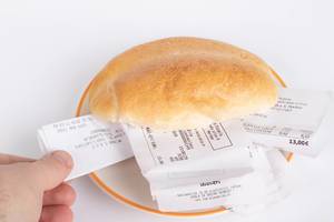 Bread roll full of receipts with human hand