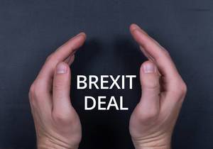 Brexit Deal Text mit Männerhänden vor schwarzem Hintergrund