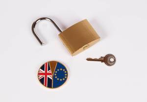 Brexit Medaille mit offenem Vorhängeschloss und Schlüssel vor weißem Hintergrund