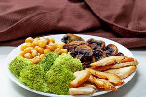 Broccoli with chickpeas, mushrooms and chicken on a white plate (Flip 2019)