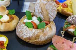 Brot aufgeschnitten mit Basilikum, Tomaten und Mozzarella als Inhalt