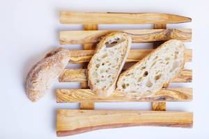 Brotscheiben von selbstgebackenem Brot auf einem Holzbrettchen
