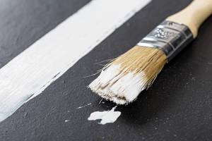 Brush and strip of white paint on black background (Flip 2019)
