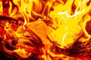 Buchseiten verbrennen im Feuer mit hellen Flammen