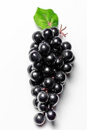Bunch of black grapes on a white background. The view from the top (Flip 2020)