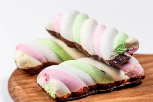 Bunte Schaumzucker-Marshmallow Süßigkeiten auf einem Küchenbrettchen