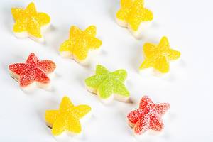 Bunte Süßigkeiten aus Gelee in Form von Seesternen, vor weißem Hintergrund
