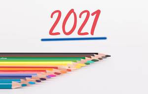 Buntstifte vor weißem Hintergrund mit rotem "2021" Text