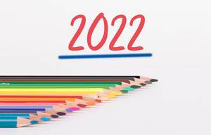 Buntstifte vor weißem Hintergrund mit rotem "2022" Text