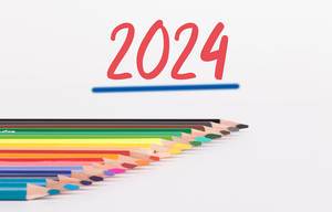 Buntstifte vor weißem Hintergrund mit rotem "2024" Text