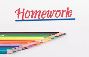 Buntstifte vor weißem Hintergrund mit rotem "Homework" Text