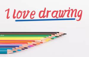 Buntstifte vor weißem Hintergrund mit rotem "I love drawing" Text