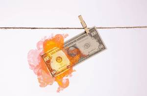 Burning dollar banknote hanging on a clothes line