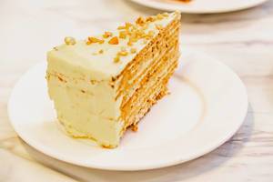 Butter-creamed cake slice on marble white table