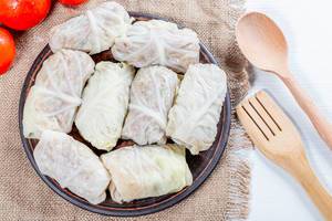 Cabbage rolls with meat and rice on burlap with wooden spoon and fork (Flip 2019)