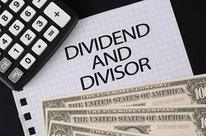 Calculator, money and Dividend and Divisor text on black table