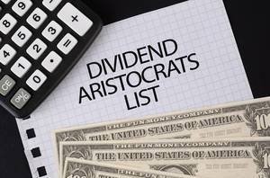 Calculator, money and Dividend Aristocrats List text on black table