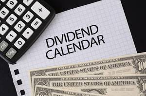 Calculator, money and Dividend Calendar text on black table
