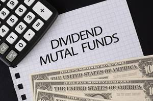 Calculator, money and Dividend Mutal Funds text on black table