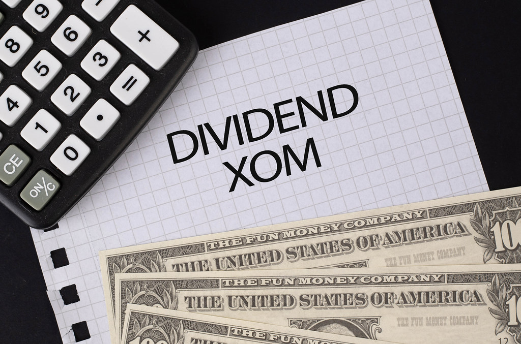 Calculator, money and Dividend XOM text on black table