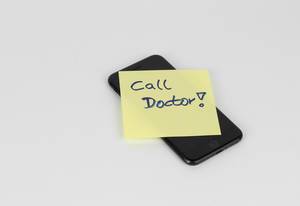 Call doctor on sticky note on cell phone