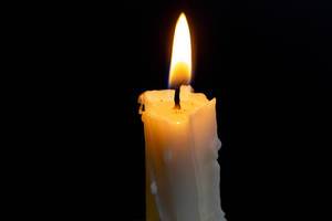 Candle burning brightly in the black background
