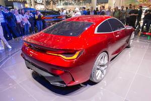 Car exhibition visitors taking pictures of red sports car by BMW Concept 4 Series Coupé