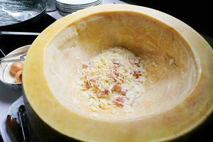 Carbonara spaghetti cooking in parmesan cheese wheel