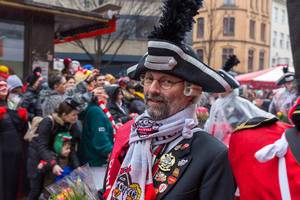 Carnival in Cologne: man in traditional hat and jacket wearing many pins with symbols of the city of Cologne at the Rose Monday parade