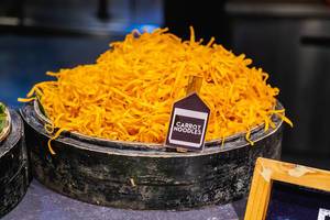 Carrot noodles on wooden bowl