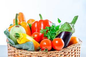 Carrots, bell peppers,balajan, tomatoes, zucchini and parsley in a wicker basket close-up (Flip 2019)