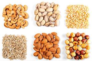 Cashew nuts, pistachios, pine nuts, almonds, hazelnuts and sunflower seeds on a white background