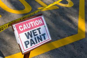 Caution Wet Paint - street sign with caution tape
