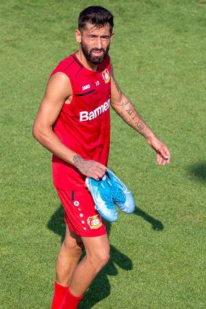 Central midfield soccer player Kerem Demirbay carries his sports shoes after training  and leaving the pitch