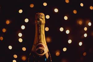 Champagnerflasche in festlicher Atmosphäre vor Lichtermeer im Hintergrund
