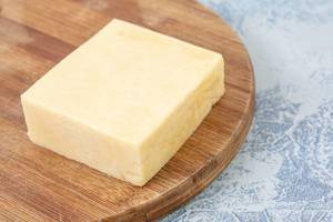Cheddar Yellow Cheese on the kitchen wooden board (Flip 2019)