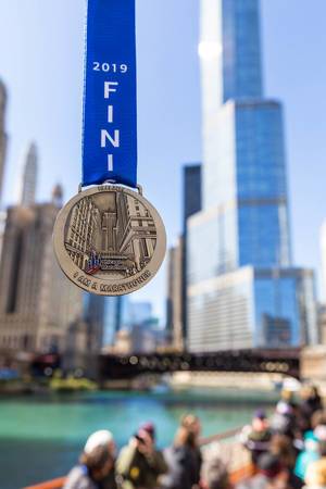 Chicago Marathon Finisher Medal 2019 with the Trump Tower and the Chicago River in the background