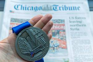 Chicago Marathon Medaille mit blauem Band und Sportbericht der Chicago Tribune Tageszeitung im Hintergrund