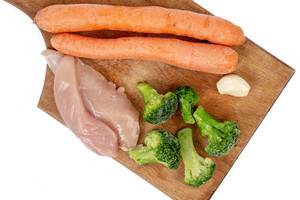Chicken breasts with Carrots Broccoli and Garlic on the wooden board (Flip 2019)