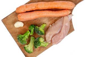 Chicken breasts with Carrots Broccoli and Garlic on the wooden board