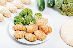 Chicken cutlets with fresh broccoli on a white plate