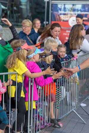 Children congratulate marathon runners with high-fives shortly before finishing the Ironman 70.3 Triathlon in Lahti, Finland