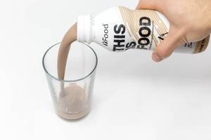 Chilled chocolate milk drink is poured into glass