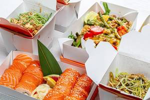 Chinesisches Essen in Kartonboxen, Salat, Sushi, Nudeln und Reis