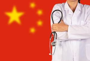 Chinesisches Gesundheitssystem symbolisiert durch die Nationalflagge und eine Ärztin mit Stethoskop in der Hand