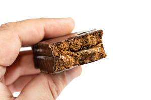 Chocolate Bar with Caramel in the hand above white background