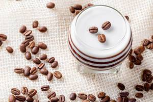 Chocolate-milk dessert with coffee beans on the background of burlap